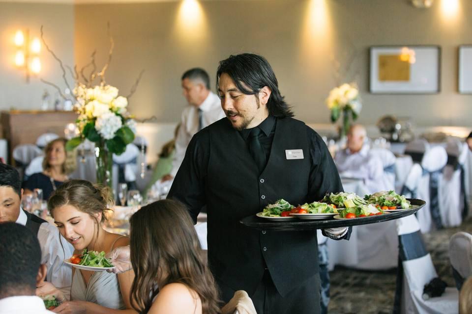 Gestion des extras en restauration lors d'un événement : serveurs en service dans une salle de réception, illustration des contrats d'extra, de la paie et de la gestion du personnel HCR.